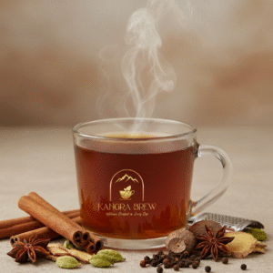 A clear glass cup of steaming Masala Tea without milk, branded with the gold Kangra Brew logo. Spices like cinnamon, cardamom, cloves, ginger, nutmeg, star anise, and peppercorns are artfully arranged around the base, all set against a warm, neutral background