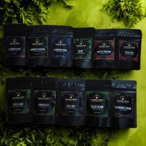 A product photo showcasing 11 varieties of Kangra Brew tea pouches, including Kashmiri Kahwa, Immunity Infusion, Blueberry Bliss, Detox, Orange Cinnamon, Petal Kiss, Tulsi Elixir, Lemongrass, Earl Grey, Valley Bloom, and Chamomile Charm. Each pouch is 10g.